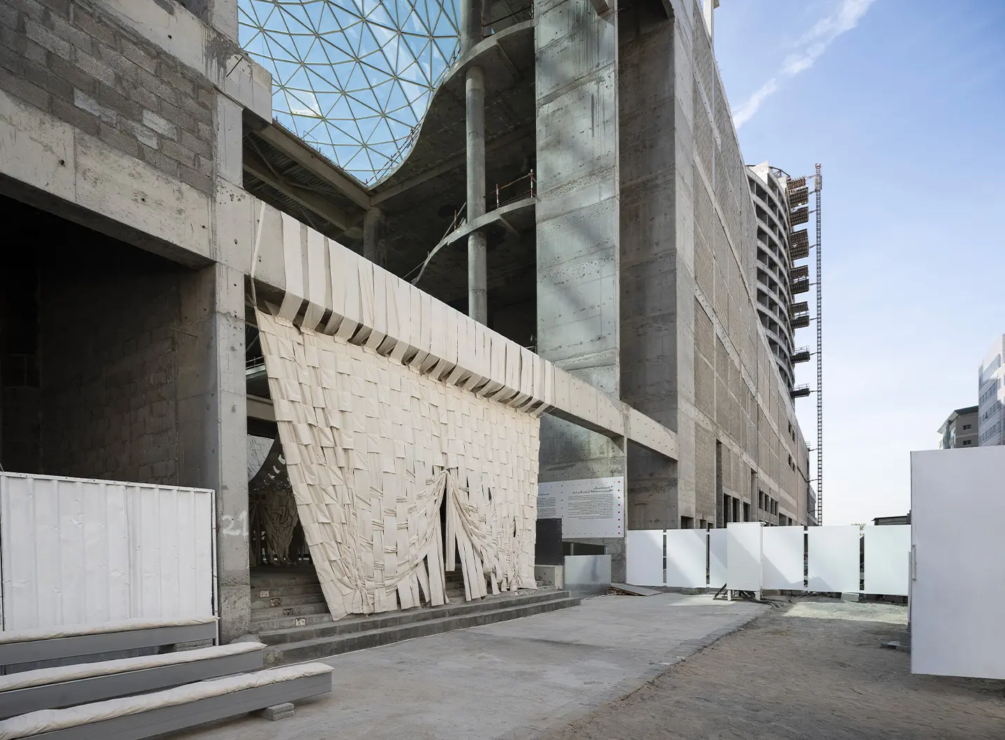 Al Madam 沙漠鬼村中的 Concrete Tent 混凝土帐篷装置，半埋沙丘的荒芜景象